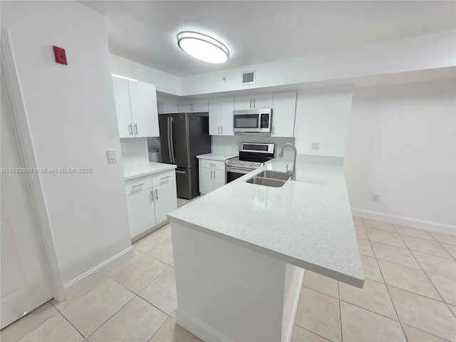 2620 S University Dr Unit 111, Davie, FL 33328 - kitchen featuring stainless steel appliances, light tile patterned flooring, a peninsula, and white cabinets