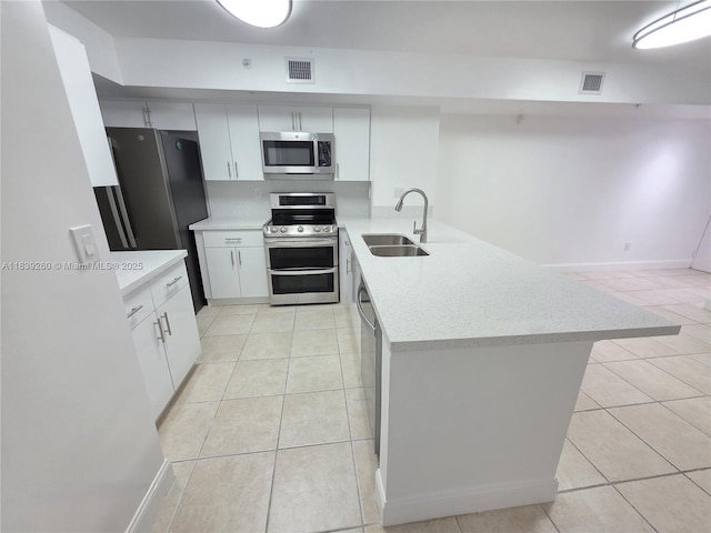 2620 S University Dr Unit 111, Davie, FL 33328 - kitchen featuring stainless steel appliances, a peninsula, light tile patterned floors, white cabinets, and light stone counters