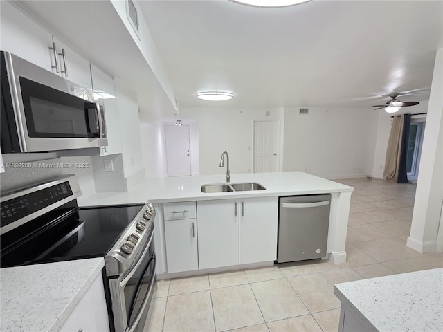 2620 S University Dr Unit 111, Davie, FL 33328 - kitchen with stainless steel appliances, light tile patterned floors, a peninsula, and light countertops