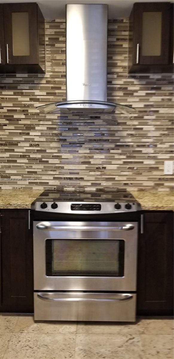 1337 Euclid Ave Unit 101, Miami Beach, FL 33139 - kitchen featuring gas range, extractor fan, tasteful backsplash, and dark brown cabinets