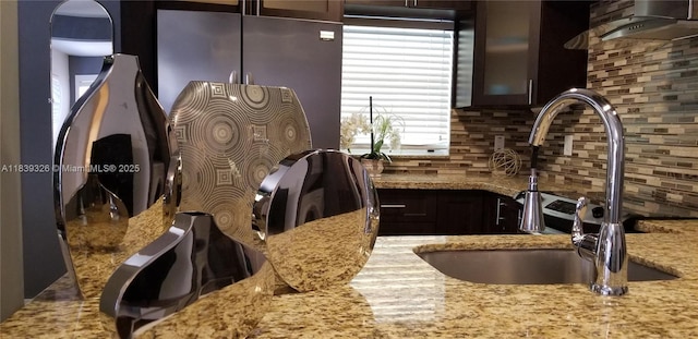 1337 Euclid Ave Unit 101, Miami Beach, FL 33139 - kitchen with light stone countertops, decorative backsplash, glass insert cabinets, and range hood