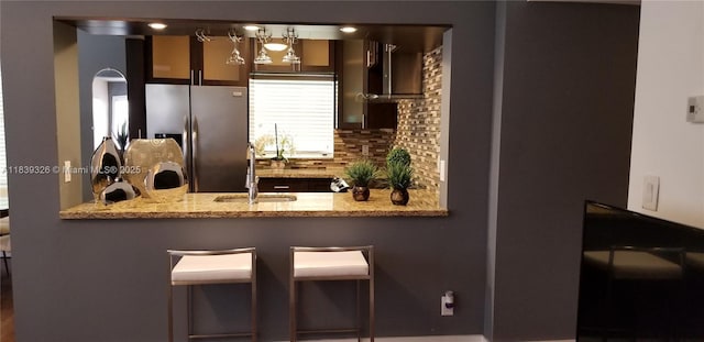 1337 Euclid Ave Unit 101, Miami Beach, FL 33139 - kitchen featuring stainless steel fridge, a peninsula, backsplash, and light stone countertops
