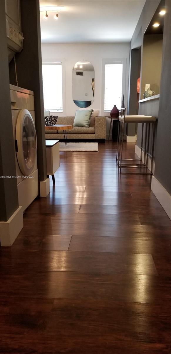 1337 Euclid Ave Unit 101, Miami Beach, FL 33139 - hall featuring dark wood-style floors, plenty of natural light, and estacked washer and dryer