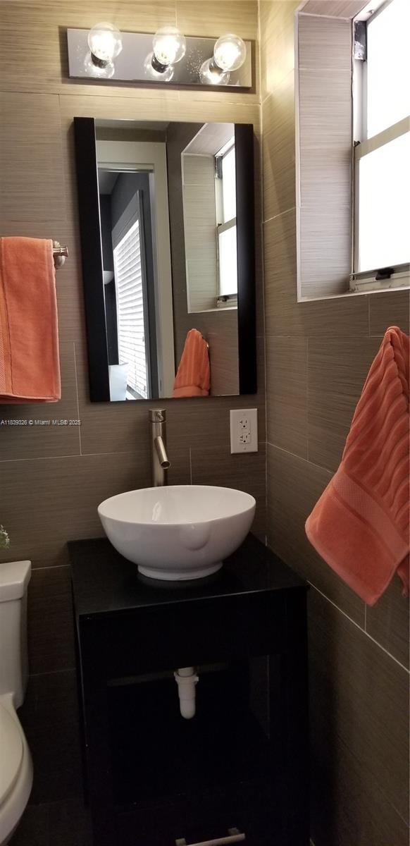 1337 Euclid Ave Unit 101, Miami Beach, FL 33139 - bathroom with tile walls, vanity, and backsplash