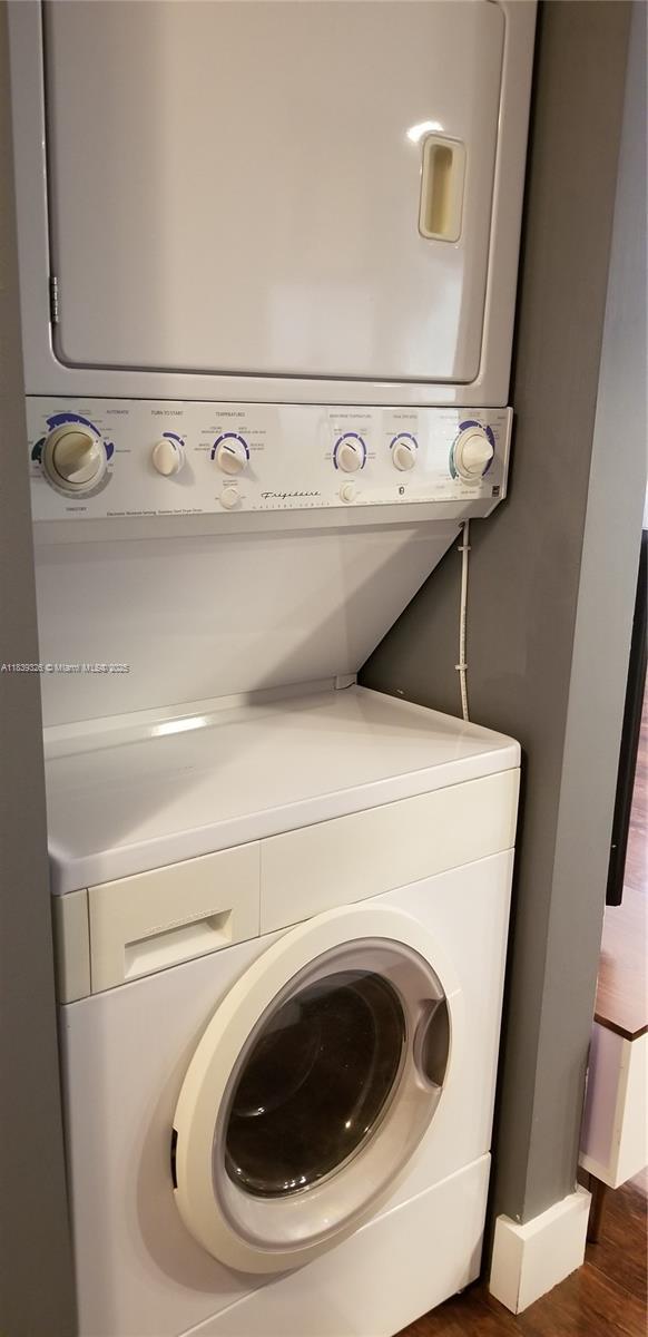 1337 Euclid Ave Unit 101, Miami Beach, FL 33139 - laundry room featuring stacked washer / drying machine and dark wood finished floors