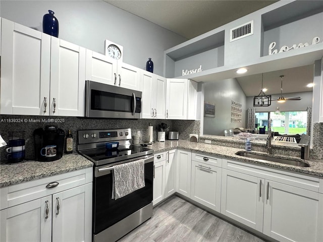 5928 NW 93rd Ter, Tamarac, FL 33321 - kitchen with stainless steel appliances, tasteful backsplash, white cabinets, light wood-style floors, and light stone countertops