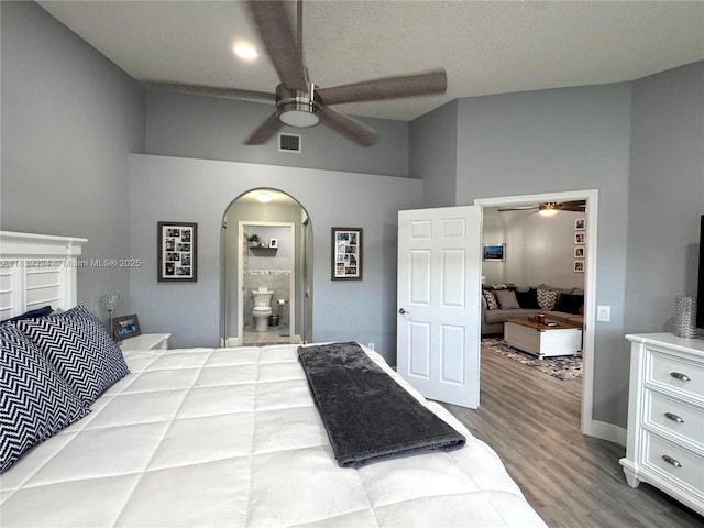 5928 NW 93rd Ter, Tamarac, FL 33321 - bedroom featuring wood finished floors, arched walkways, ensuite bathroom, a ceiling fan, and lofted ceiling