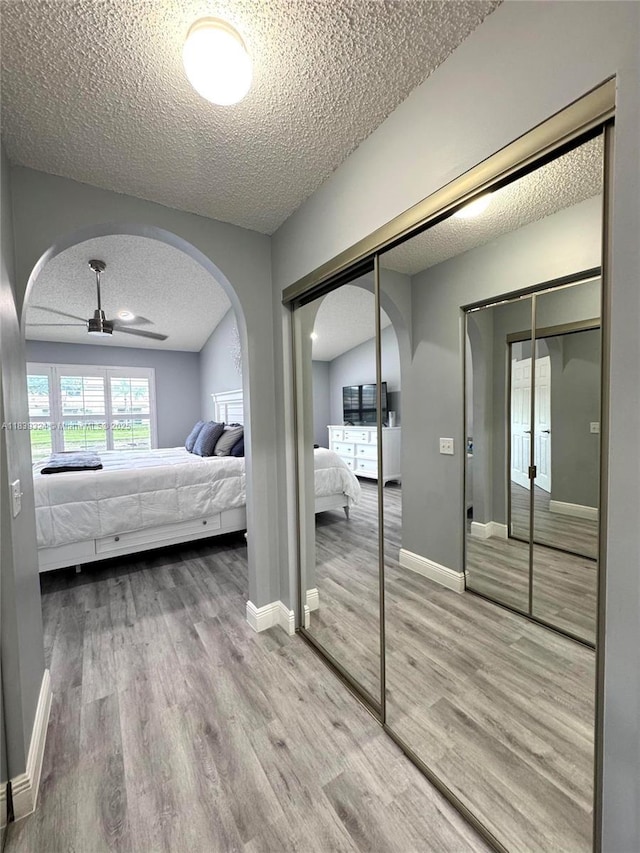 5928 NW 93rd Ter, Tamarac, FL 33321 - bedroom featuring arched walkways, a textured ceiling, wood finished floors, and a closet