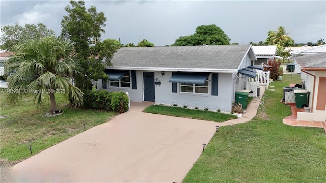 8521 NW 57th Ct, Tamarac, FL 33321 - view of front facade with roof with shingles, a front lawn, and concrete driveway