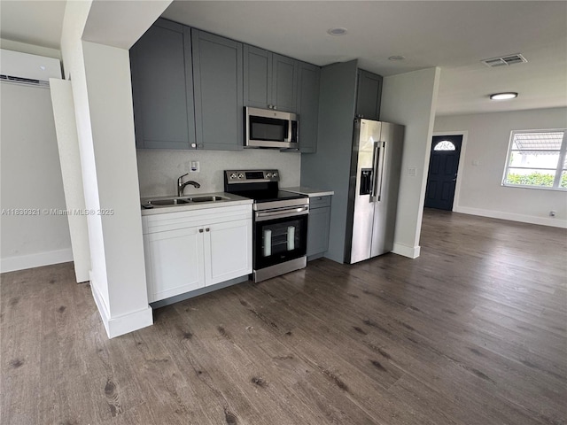 8521 NW 57th Ct, Tamarac, FL 33321 - kitchen with appliances with stainless steel finishes, dark wood-style floors, a wall mounted air conditioner, and light countertops
