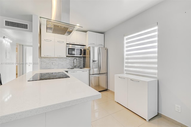 471 Capri J Unit 471, Delray Beach, FL 33484 - kitchen featuring appliances with stainless steel finishes, tasteful backsplash, white cabinetry, light tile patterned flooring, and a peninsula