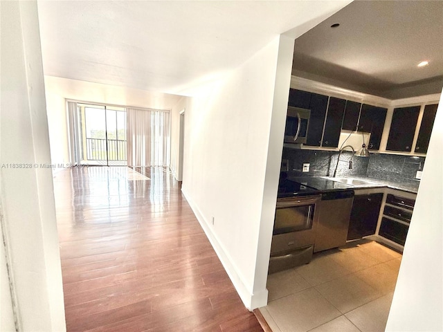 20335 W Country Club Dr Unit 502, Aventura, FL 33180 - kitchen featuring appliances with stainless steel finishes, tasteful backsplash, dark cabinets, light wood finished floors, and recessed lighting