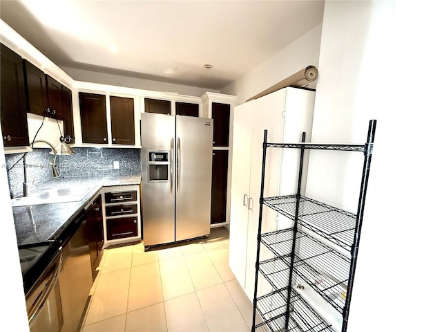 20335 W Country Club Dr Unit 502, Aventura, FL 33180 - kitchen with appliances with stainless steel finishes, dark brown cabinets, dark stone counters, tasteful backsplash, and light tile patterned floors