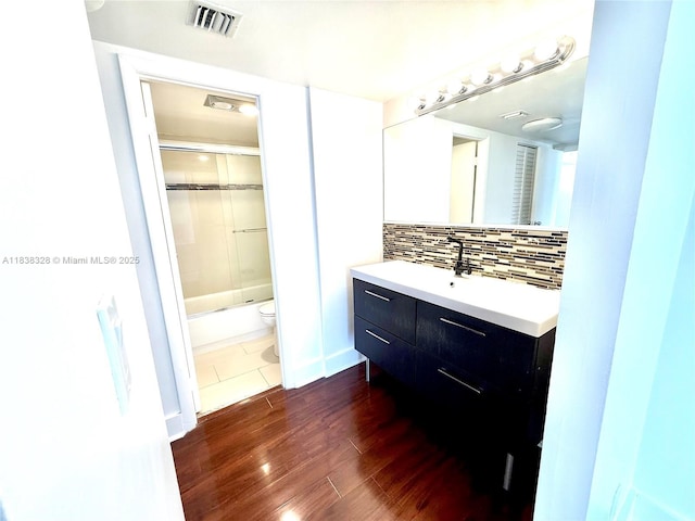 20335 W Country Club Dr Unit 502, Aventura, FL 33180 - full bath featuring vanity, backsplash, wood finished floors, and shower / bath combination with glass door
