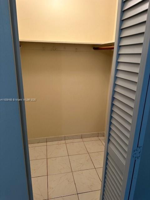 720 Collins Ave Unit 310, Miami Beach, FL 33139 - walk in closet featuring marble look tiles