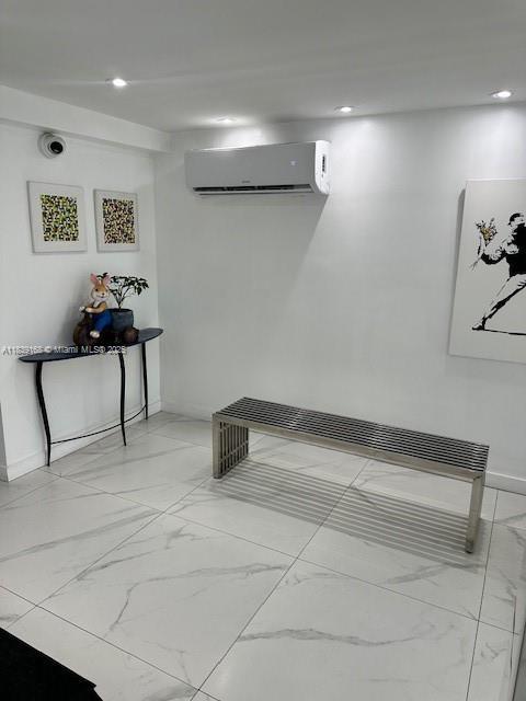 720 Collins Ave Unit 310, Miami Beach, FL 33139 - interior space with a wall mounted air conditioner, light marble finish floors, and recessed lighting