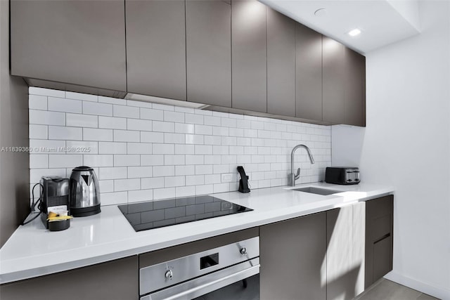 227 NE 2nd St Unit 2000, Miami, FL 33132 - kitchen featuring stainless steel oven, black electric cooktop, decorative backsplash, and modern cabinets