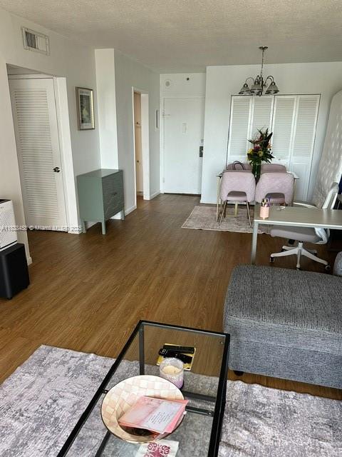 400 S Kings Point Dr Unit 806, Sunny Isles Beach, FL 33160 - living area with wood finished floors, a chandelier, and a textured ceiling