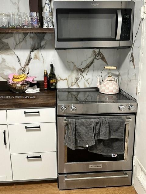400 S Kings Point Dr Unit 806, Sunny Isles Beach, FL 33160 - detailed view of appliances with stainless steel finishes, backsplash, white cabinets, and wood counters