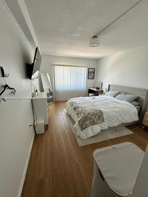 400 S Kings Point Dr Unit 806, Sunny Isles Beach, FL 33160 - bedroom with a textured ceiling and wood finished floors