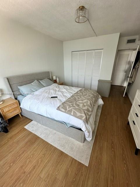 400 S Kings Point Dr Unit 806, Sunny Isles Beach, FL 33160 - bedroom featuring a closet, wood finished floors, and a textured ceiling