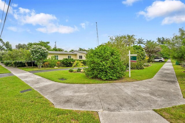 85 NW 21st St, Homestead, FL 33030 - view of property hidden behind natural elements with a front lawn and stucco siding