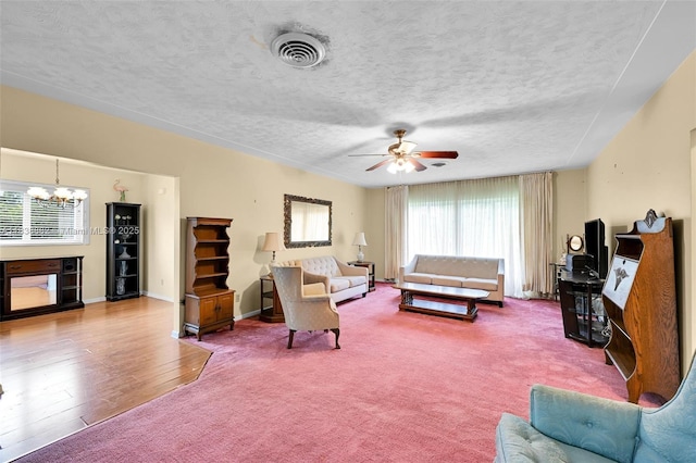 85 NW 21st St, Homestead, FL 33030 - carpeted living area with a chandelier, a ceiling fan, a textured ceiling, and wood finished floors