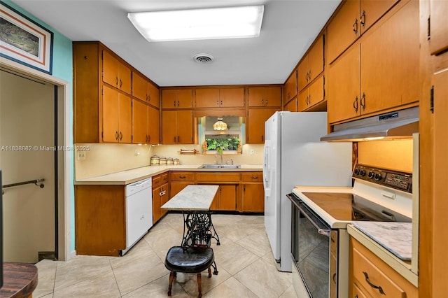 85 NW 21st St, Homestead, FL 33030 - kitchen featuring white appliances, under cabinet range hood, light countertops, and brown cabinetry