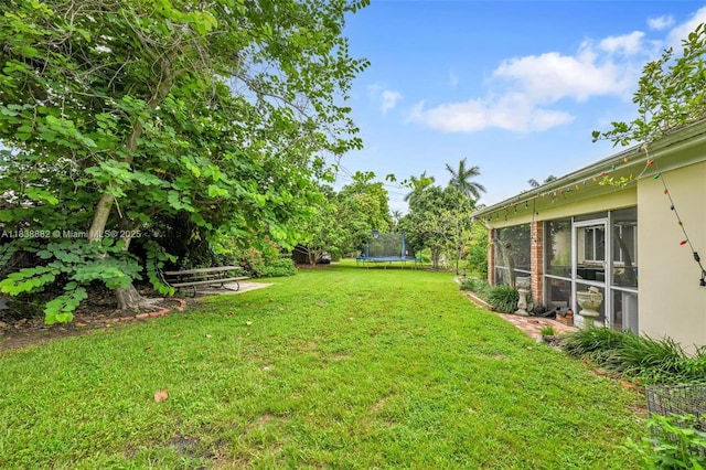 85 NW 21st St, Homestead, FL 33030 - view of green lawn featuring a trampoline and a sunroom