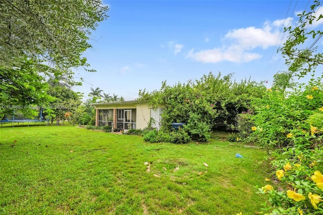 85 NW 21st St, Homestead, FL 33030 - view of grassy yard featuring a trampoline and a sunroom