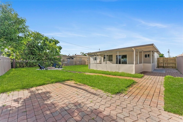 7021 SW 12th St, Pembroke Pines, FL 33023 - back of house featuring a patio, an outdoor fire pit, a fenced backyard, and stucco siding