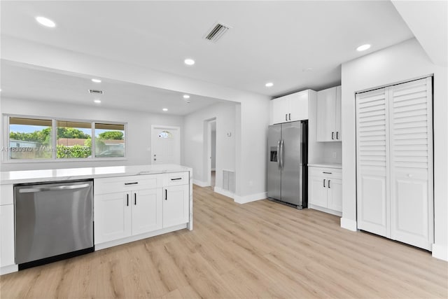 7021 SW 12th St, Pembroke Pines, FL 33023 - kitchen featuring stainless steel appliances, light wood-style floors, white cabinetry, recessed lighting, and light stone counters