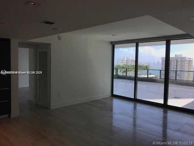 1451 Brickell Ave Unit 902, Miami, FL 33131 - unfurnished room featuring healthy amount of natural light, expansive windows, and wood finished floors
