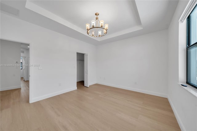 12960 SW 232nd Ln, Homestead, FL 33032 - empty room featuring a chandelier, light wood-type flooring, a raised ceiling, and healthy amount of natural light