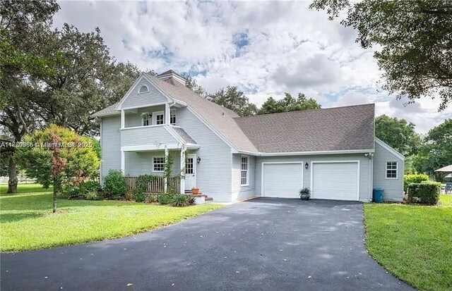 13500 SW 55th St, Southwest Ranches, FL 33330 - view of front of home with driveway, a garage, a front yard, and covered porch