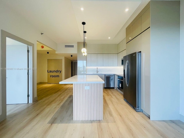 201 Crandon Blvd Unit 305, Key Biscayne, FL 33149 - kitchen with appliances with stainless steel finishes, a center island, light countertops, light wood-style floors, and hanging light fixtures