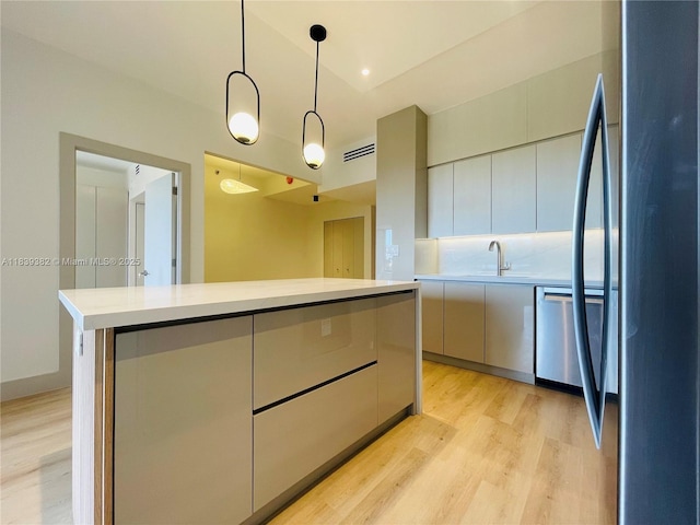 201 Crandon Blvd Unit 305, Key Biscayne, FL 33149 - kitchen with stainless steel appliances, light countertops, light wood-style flooring, modern cabinets, and pendant lighting