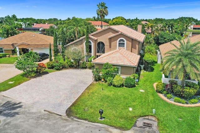 9940 SW 4th St, Plantation, FL 33324 - mediterranean / spanish-style home featuring decorative driveway, stucco siding, a tile roof, a chimney, and a front lawn