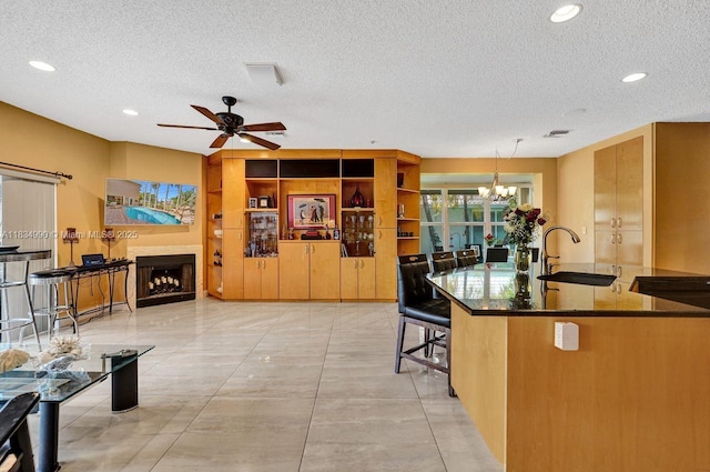 9940 SW 4th St, Plantation, FL 33324 - kitchen featuring a textured ceiling, a chandelier, a ceiling fan, recessed lighting, and a fireplace