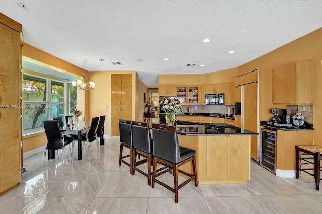 9940 SW 4th St, Plantation, FL 33324 - kitchen featuring black microwave, beverage cooler, a textured ceiling, a chandelier, and decorative backsplash