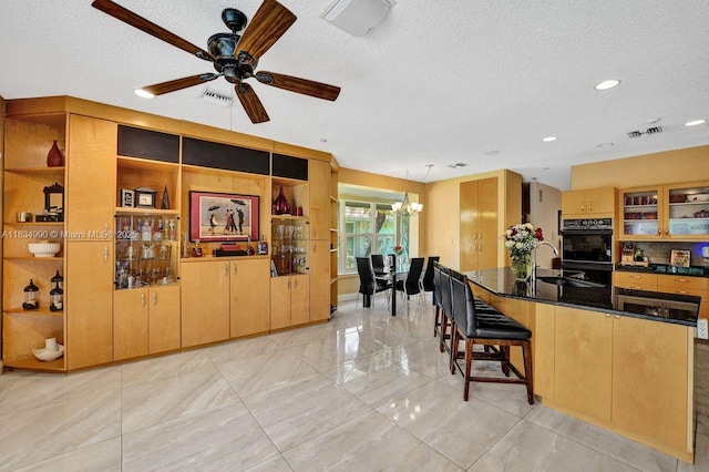 9940 SW 4th St, Plantation, FL 33324 - kitchen featuring a textured ceiling, a chandelier, a ceiling fan, a breakfast bar area, and recessed lighting