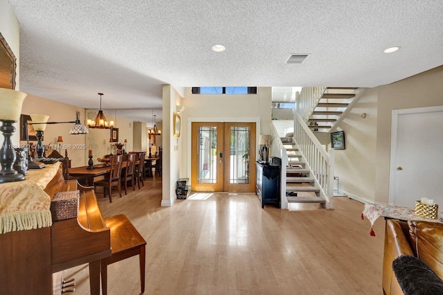 9940 SW 4th St, Plantation, FL 33324 - foyer featuring a textured ceiling, wood finished floors, french doors, stairs, and a chandelier