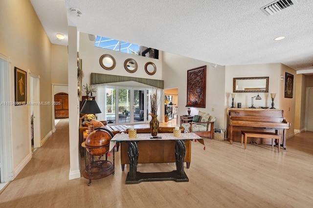 9940 SW 4th St, Plantation, FL 33324 - living room with a textured ceiling, light wood-type flooring, and a towering ceiling