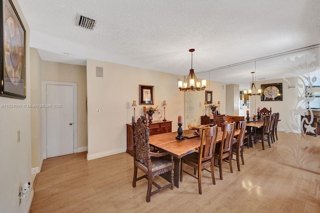 9940 SW 4th St, Plantation, FL 33324 - dining room with a chandelier, light wood-style floors, and a textured ceiling