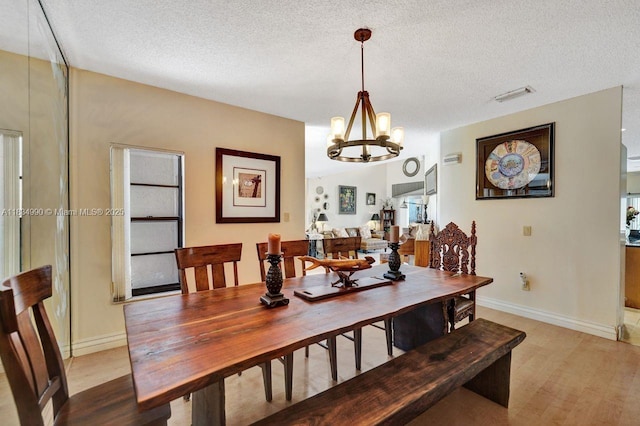 9940 SW 4th St, Plantation, FL 33324 - dining area with a chandelier, a textured ceiling, and light wood-style floors