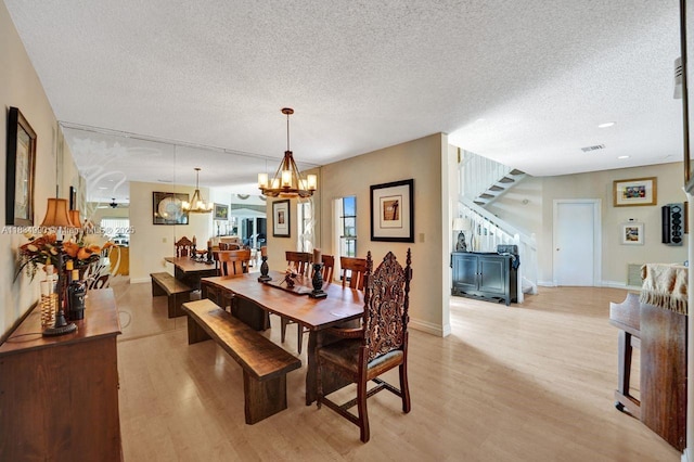 9940 SW 4th St, Plantation, FL 33324 - dining area featuring a chandelier, a textured ceiling, light wood finished floors, and stairs