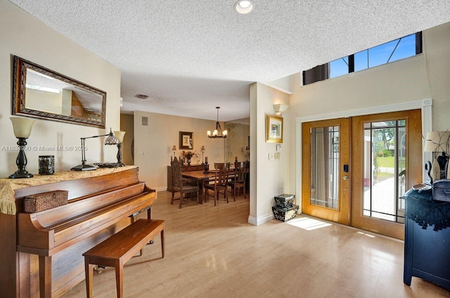 9940 SW 4th St, Plantation, FL 33324 - entrance foyer featuring light wood finished floors, a chandelier, a textured ceiling, french doors, and recessed lighting