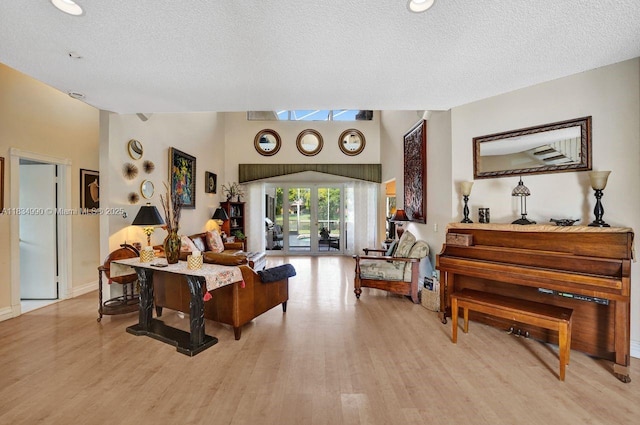 9940 SW 4th St, Plantation, FL 33324 - living room featuring a textured ceiling, light wood-style flooring, and lofted ceiling