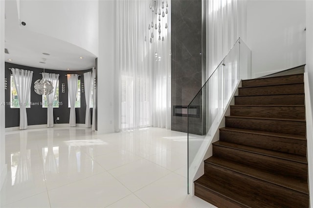 10431 NW 68th Ter, Doral, FL 33178 - stairs featuring tile patterned flooring, a towering ceiling, and arched walkways