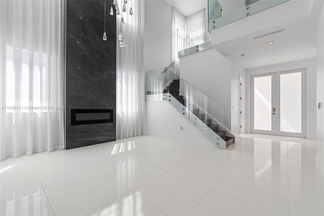 10431 NW 68th Ter, Doral, FL 33178 - unfurnished living room featuring french doors, stairway, tile patterned floors, and a fireplace